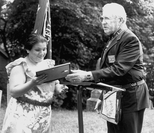 District Deputy Grand Master, R.W. Jens V. Meyer, hands certificate to Ms. Maria Santiago of Jeffersonville
